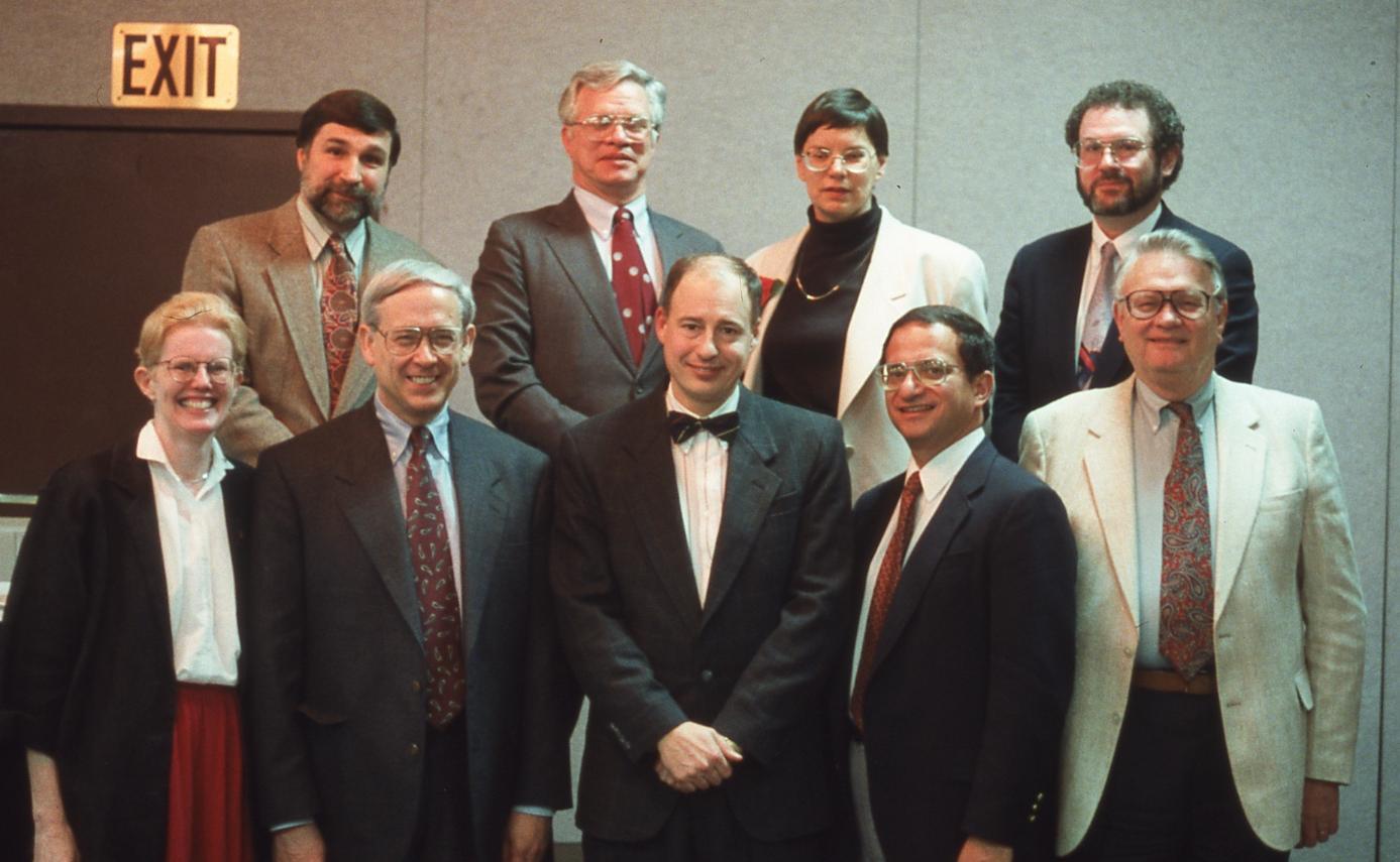 Group photo of two rows taken inside a convention hall.